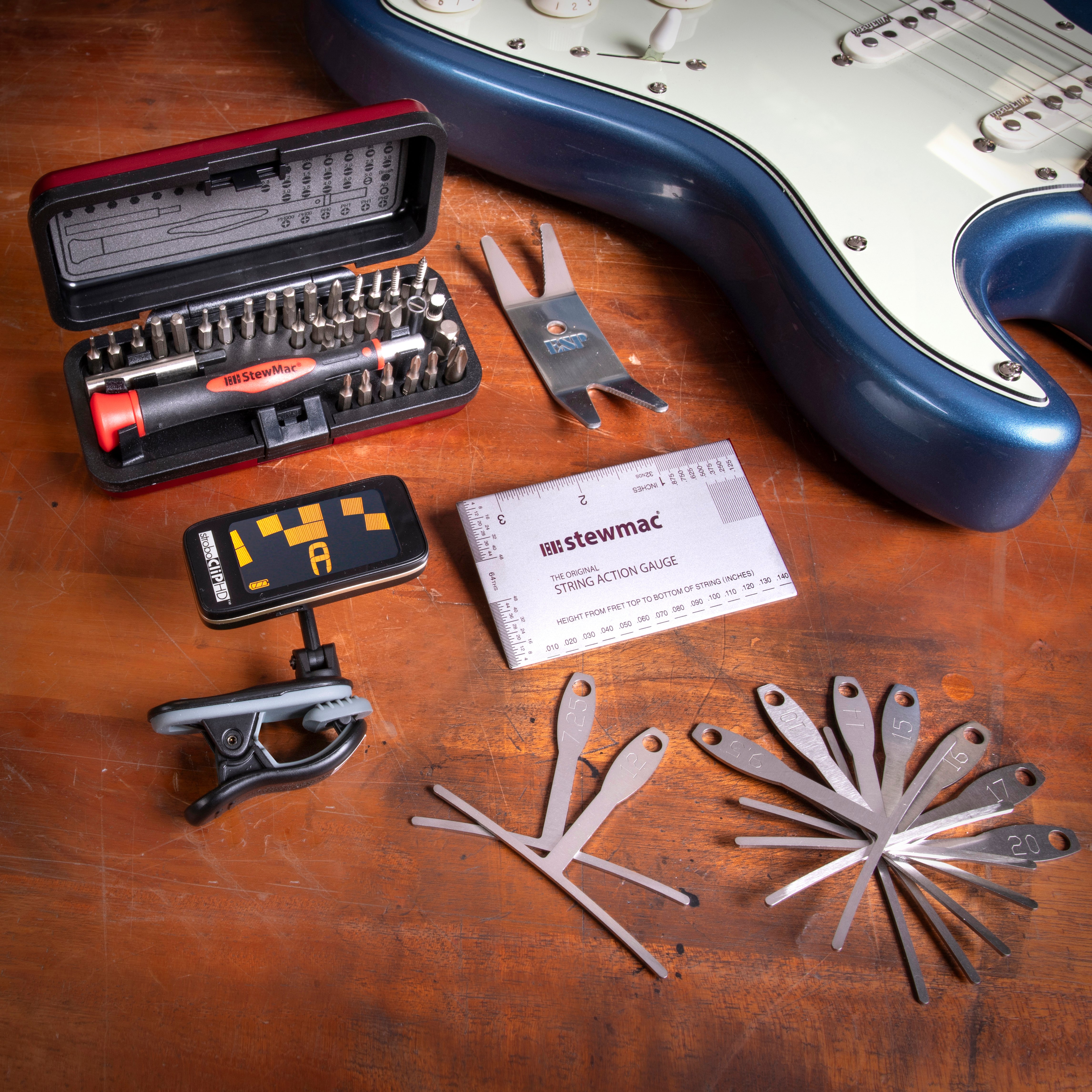 Outils utilisés dans la configuration de la guitare sur un établi avec la guitare bleue Stratocaster.