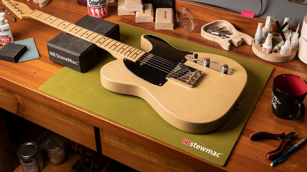Plan de travail Luthier avec guitare Fender Telecaster entourée d’outils StewMac.