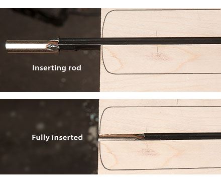 Sliding the truss rod into the end of the channel.