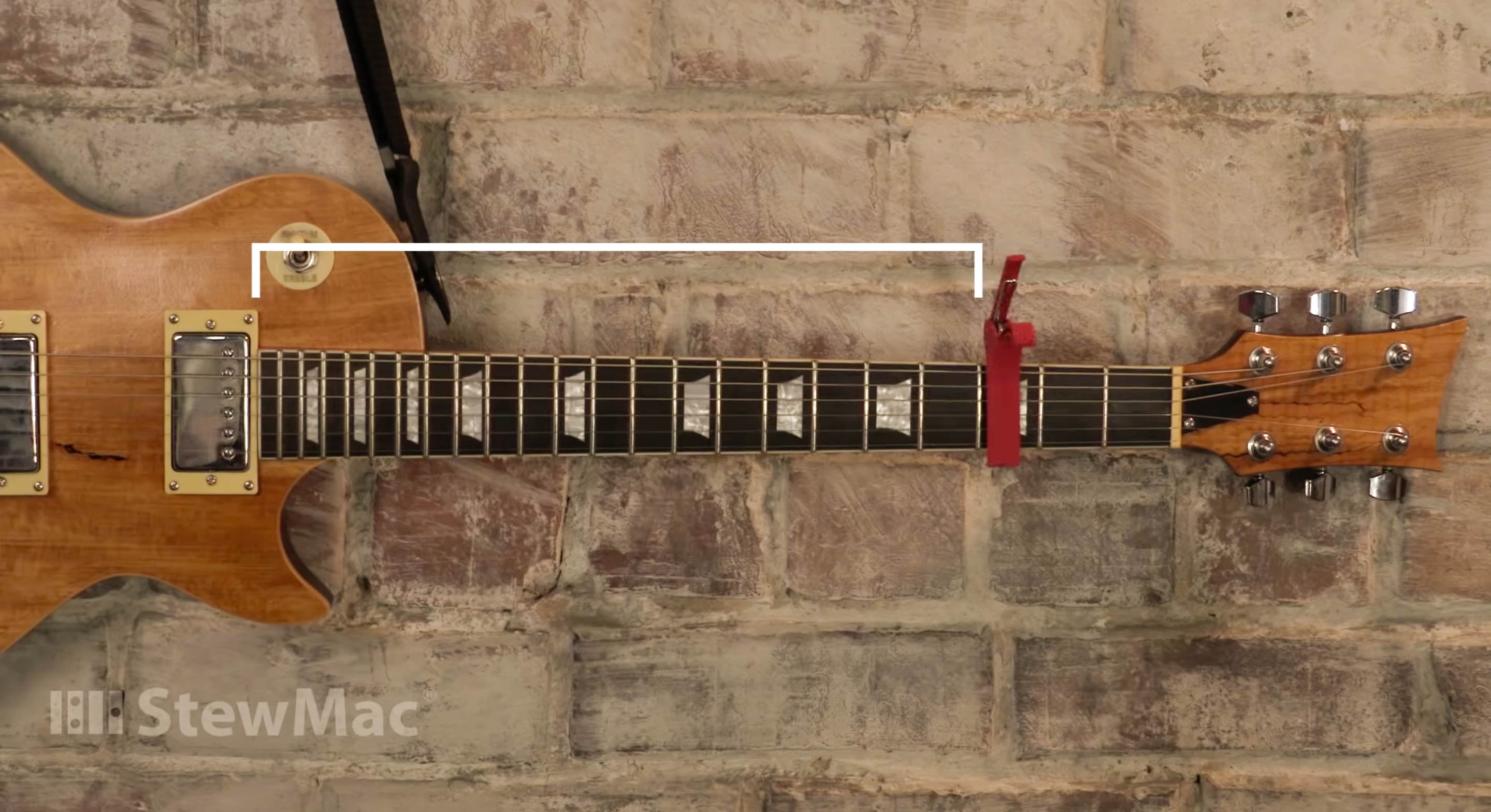 Capo fixé aux cordes sur le carton